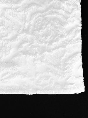 Textured white mini dress fabric with a raised floral pattern