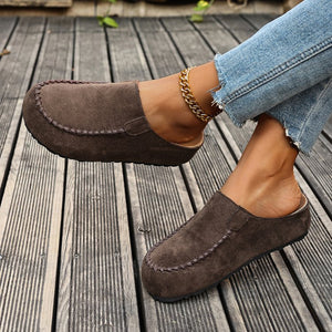 Brown suede slip-on flats with round toe and contrast stitching detail.