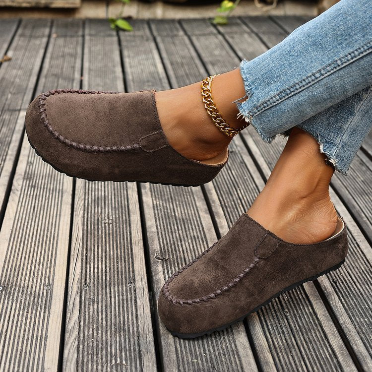 Brown suede slip-on flats with round toe and contrast stitching detail.