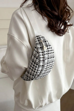 Textured houndstooth belt bag with adjustable strap and zipper closure.