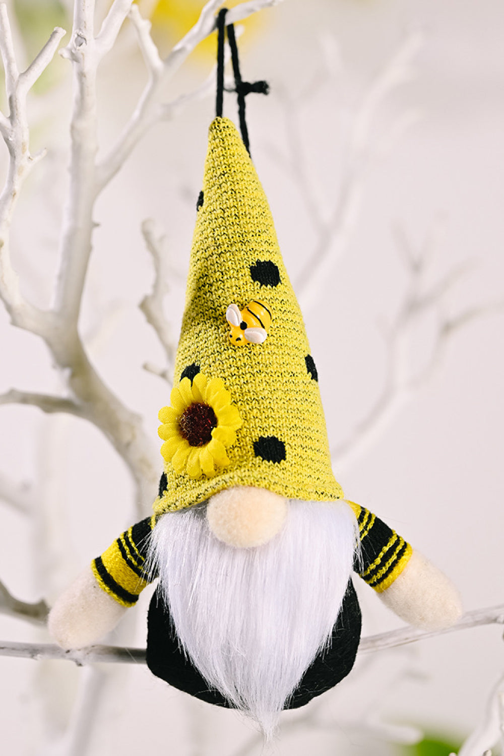 Yellow bee gnome ornament with black polka dots, sunflower, and striped sleeves.