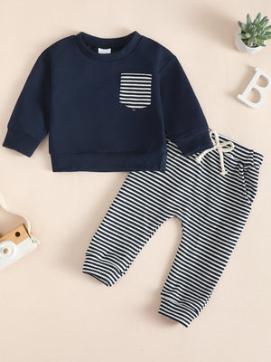 Navy blue children's sweatshirt with striped pocket and matching striped pants.