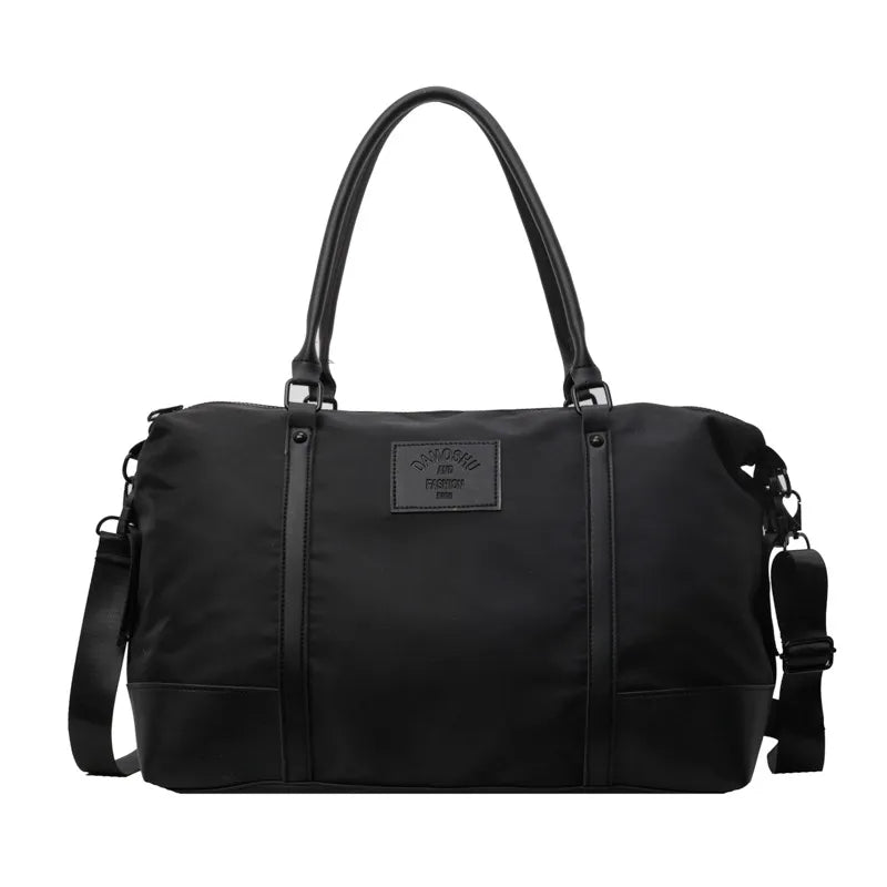 Black duffel bag with leather accents and a detachable shoulder strap.
