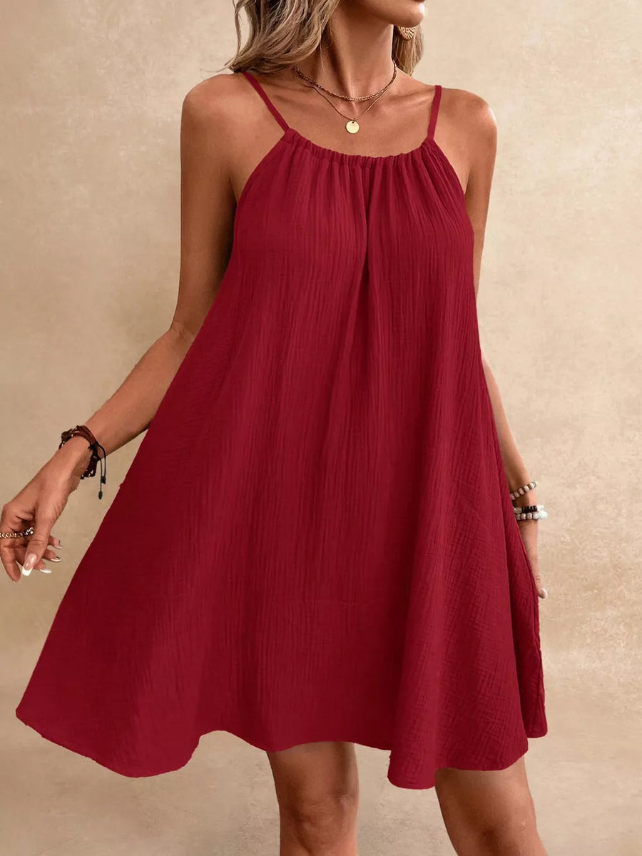 Red spaghetti strap gauze dress with a gathered neckline and A-line skirt.