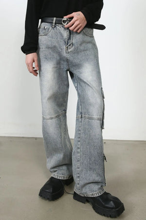 Medium wash distressed baggy cargo jeans with zippered pockets and a relaxed fit.