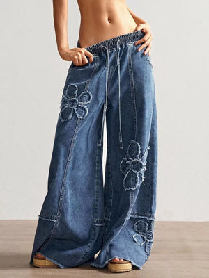 Blue denim wide leg jeans with floral applique and drawstring waist