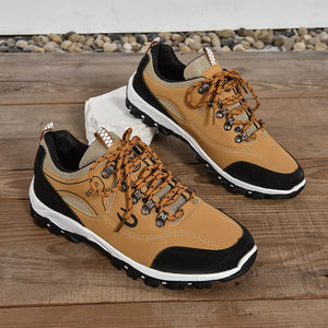 Brown lace-up low-top sneakers with patterned laces and black accents.