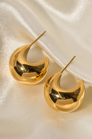 Gold sculptural crescent hoop earrings with a polished finish.