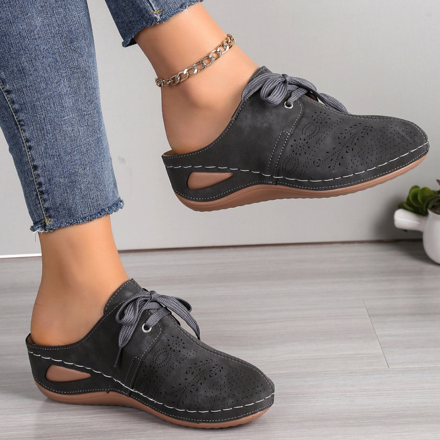 Dark gray perforated slip-on mules with lace-up detail and cut-out sides.