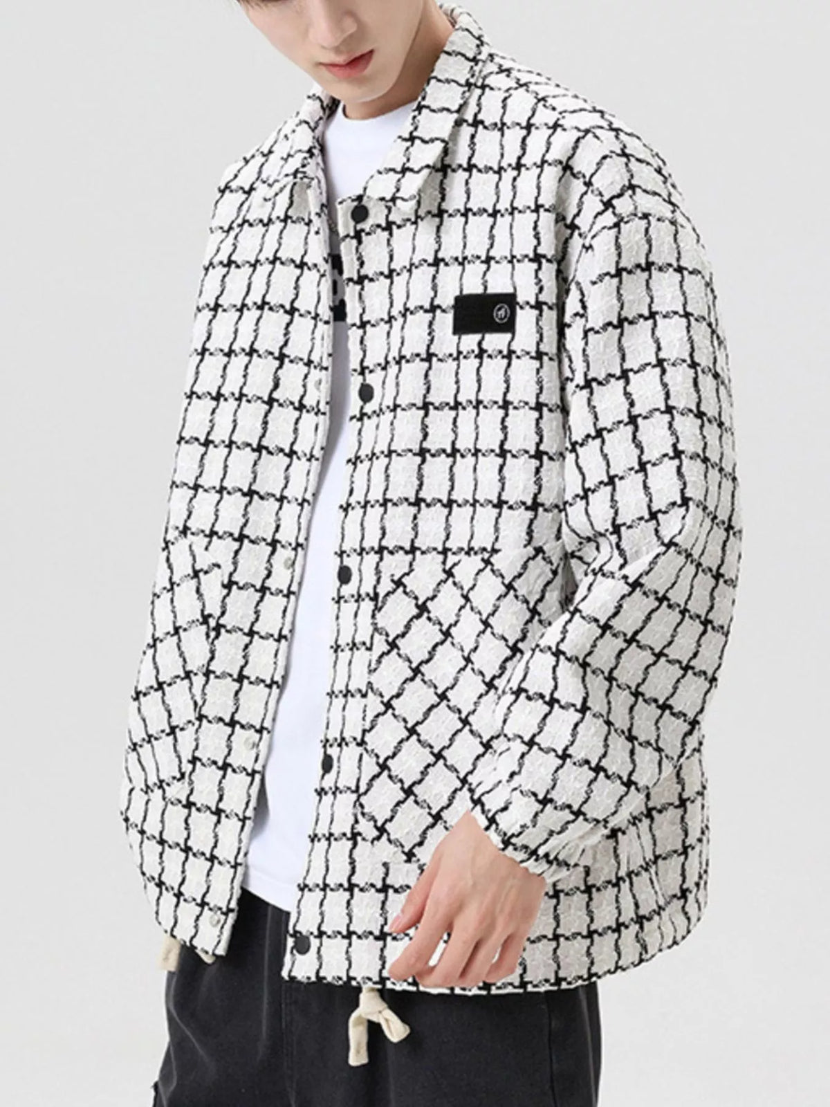 Oversized white plaid button-up jacket with black checks and a patch detail.
