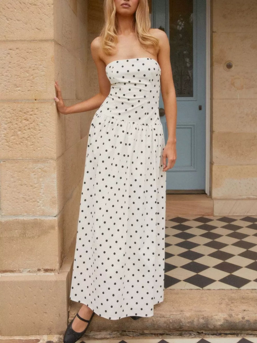 White polka dot strapless maxi dress with a tiered skirt.