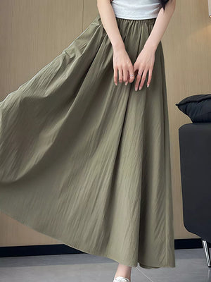 Olive green maxi skirt with pockets, featuring a crinkled texture and flowy A-line cut.