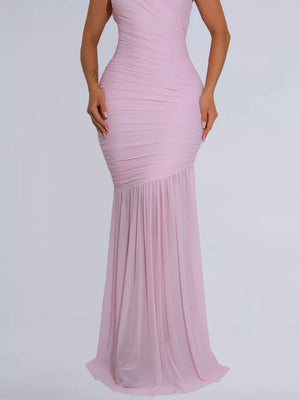 Blush pink ruched bodycon maxi dress with a draped bodice and flowing skirt.