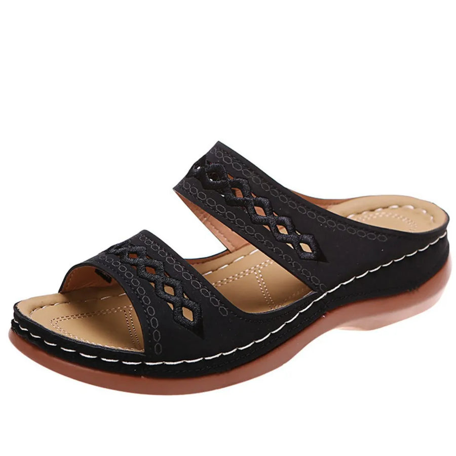 Black embroidered strap comfort slides with a cushioned footbed and wedge heel.