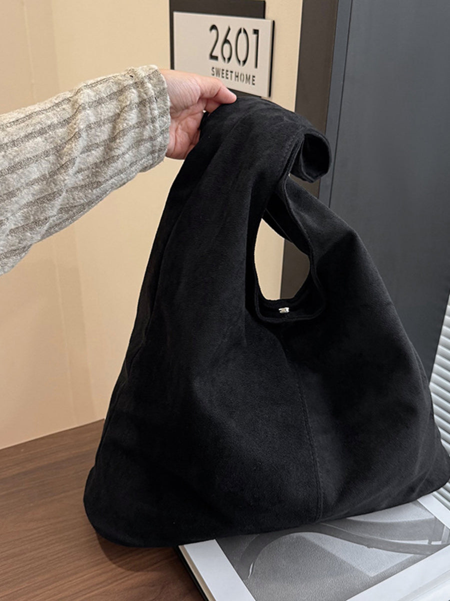 handbag in black featuring snap closure and relaxed fit