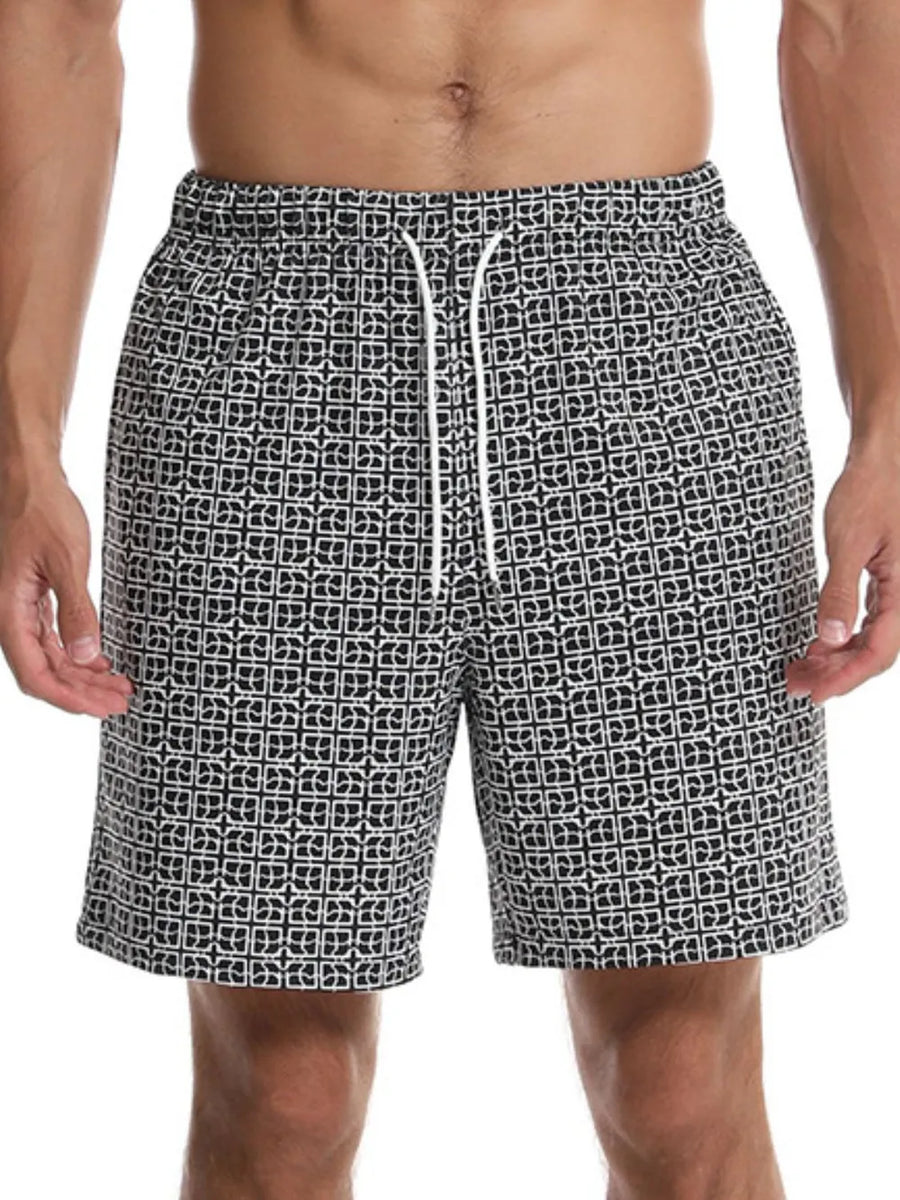 Black geometric print boardshorts with white drawstring and elastic waistband.