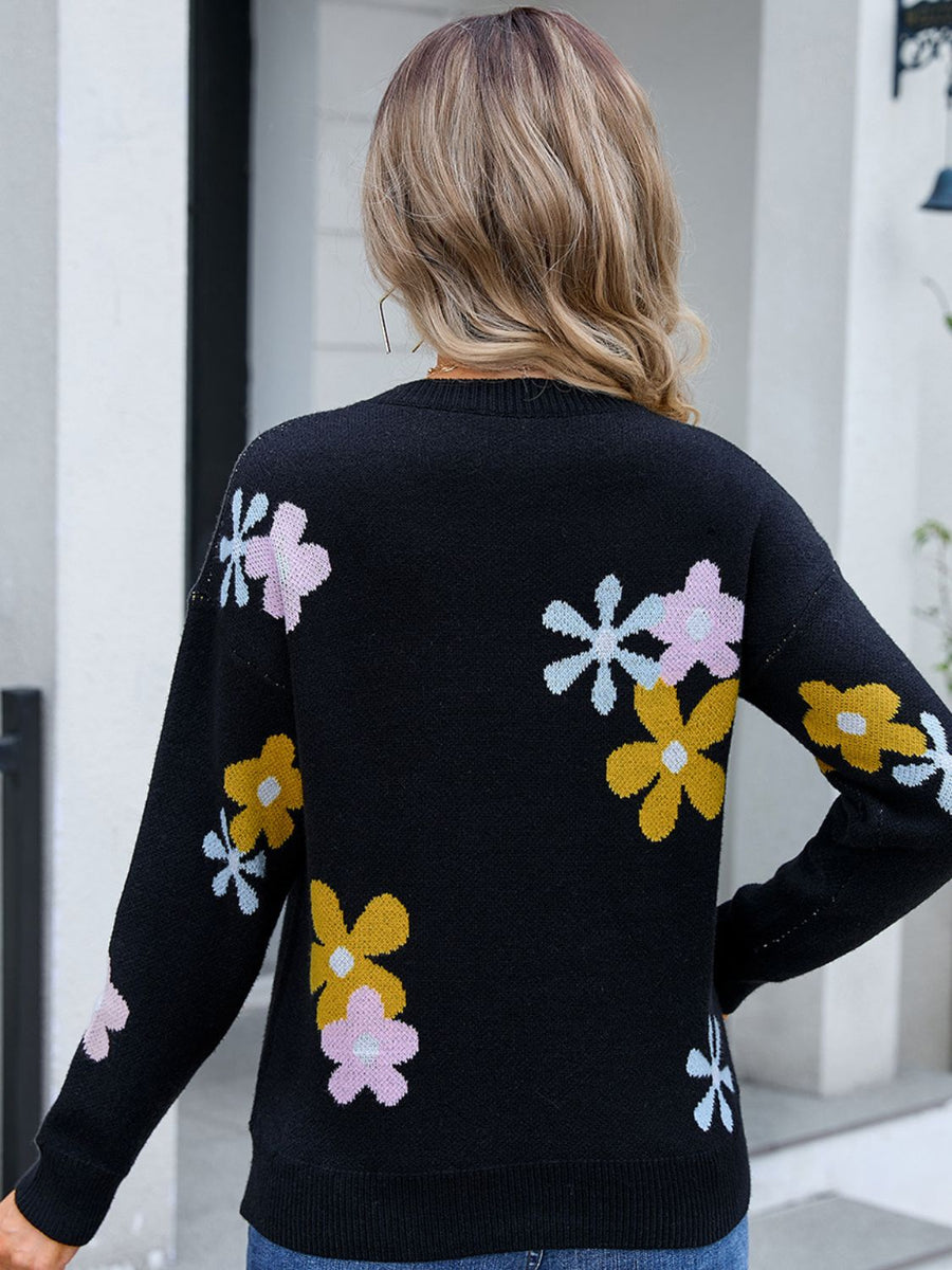 Black crewneck pullover sweater with floral intarsia knit pattern in pink, yellow, and light blue.