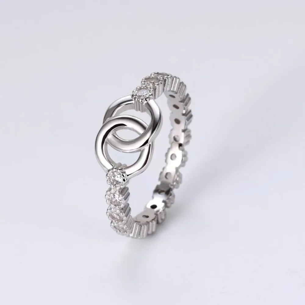 Silver eternity ring with interlocking circles and pavé cubic zirconia details.