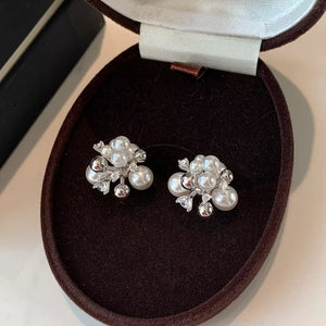 Elegant pearl cluster earrings with zircon accents in white and light gray.