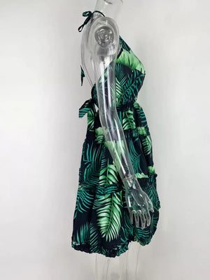 Halter mini dress with abstract green leaf print, tiered skirt, and tie detail.