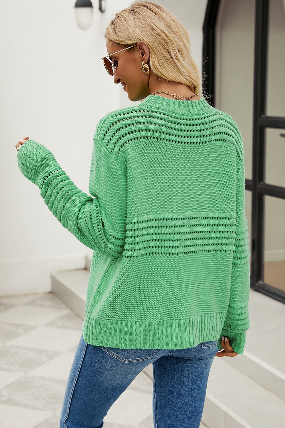 Green open-knit mock neck sweater with textured stripes and ribbed cuffs.
