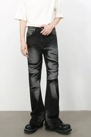 Distressed flare jeans in dark shadow wash denim with a bootcut leg and subtle rips.