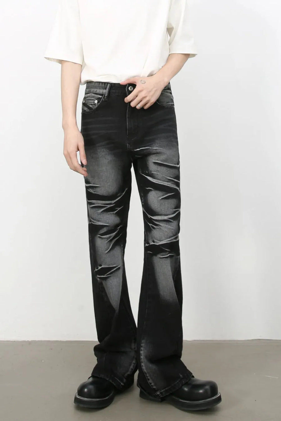 Distressed flare jeans in dark shadow wash denim with a bootcut leg and subtle rips.