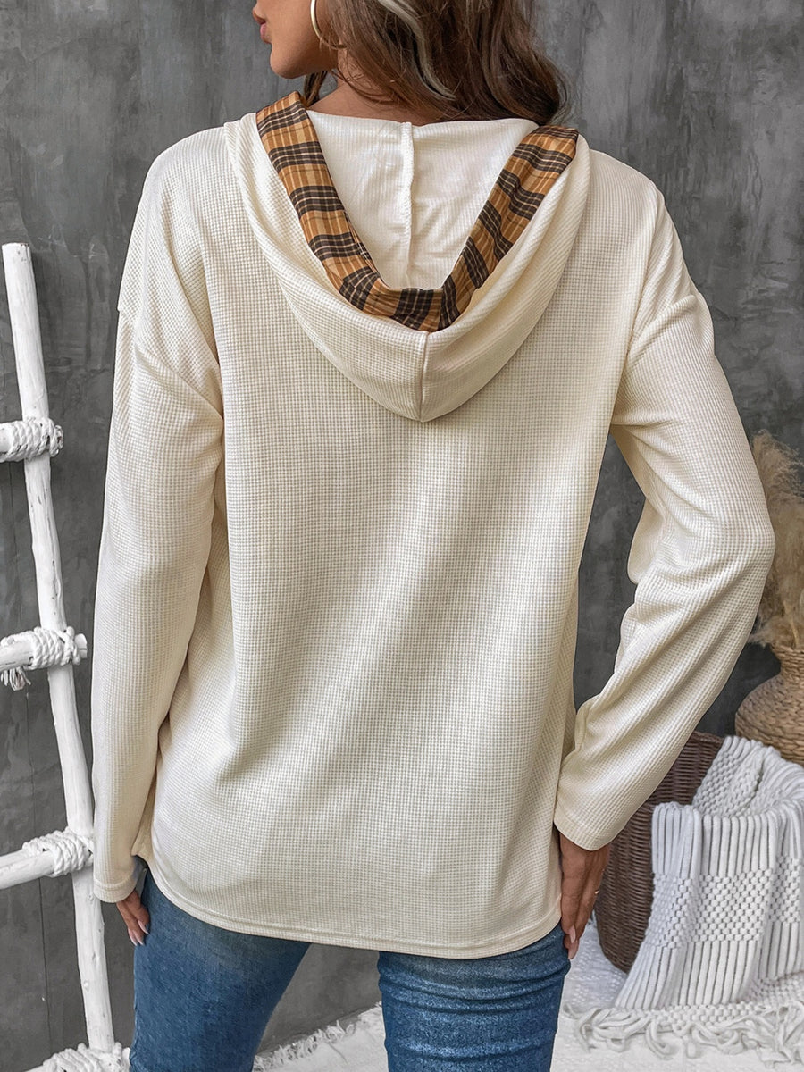 Cream waffle knit henley hooded top with plaid lining detail.