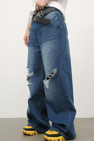 Distressed palazzo jeans in medium wash denim with ripped details and a wide leg.