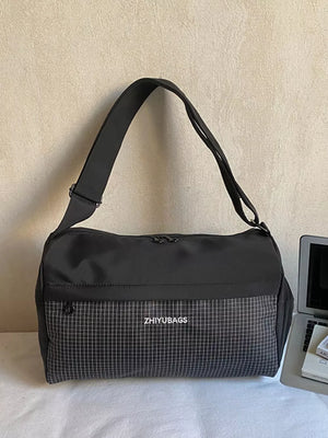 Black plaid Oxford travel bag with zipper closure and adjustable strap.