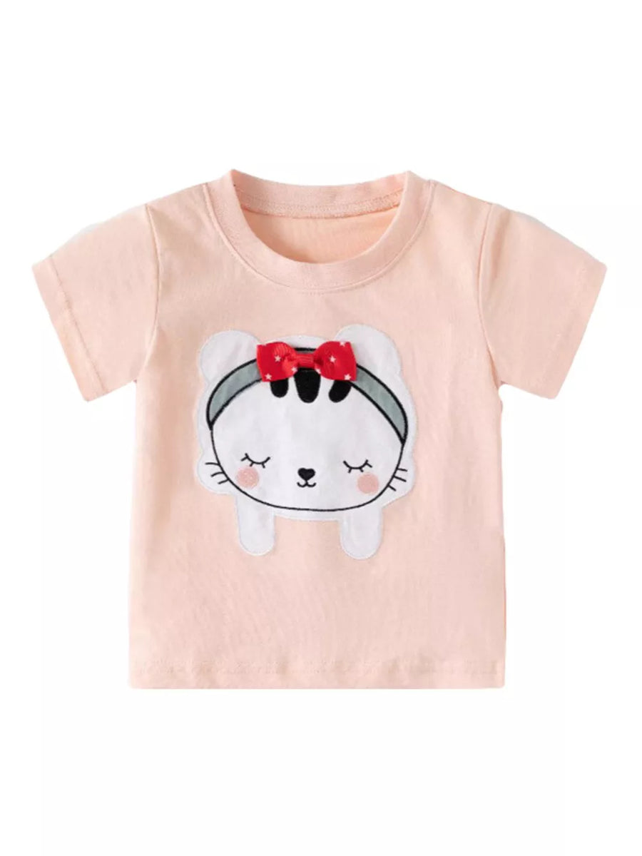 Peach toddler t-shirt with a whimsical cat appliqué featuring a red 3D bow.