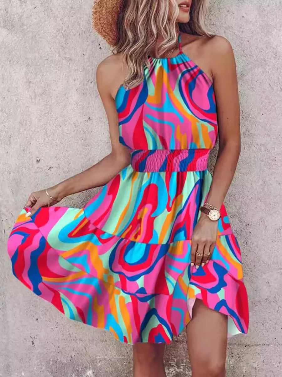 Bohemian halter mini dress with abstract print, smocked waist, and tiered skirt.