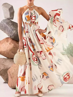 Abstract print halter maxi dress with cut-outs on a cream background, featuring colorful floral motifs.