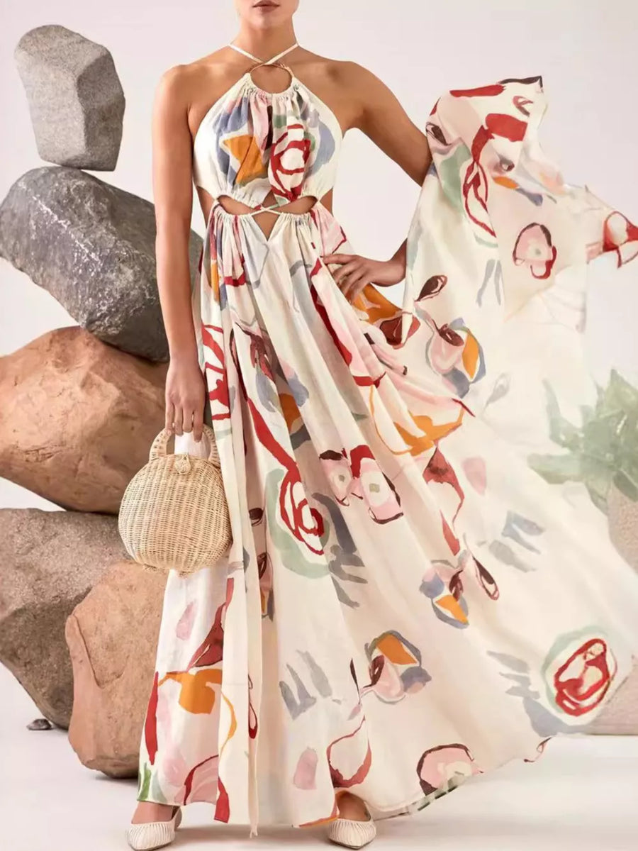 Abstract print halter maxi dress with cut-outs on a cream background, featuring colorful floral motifs.