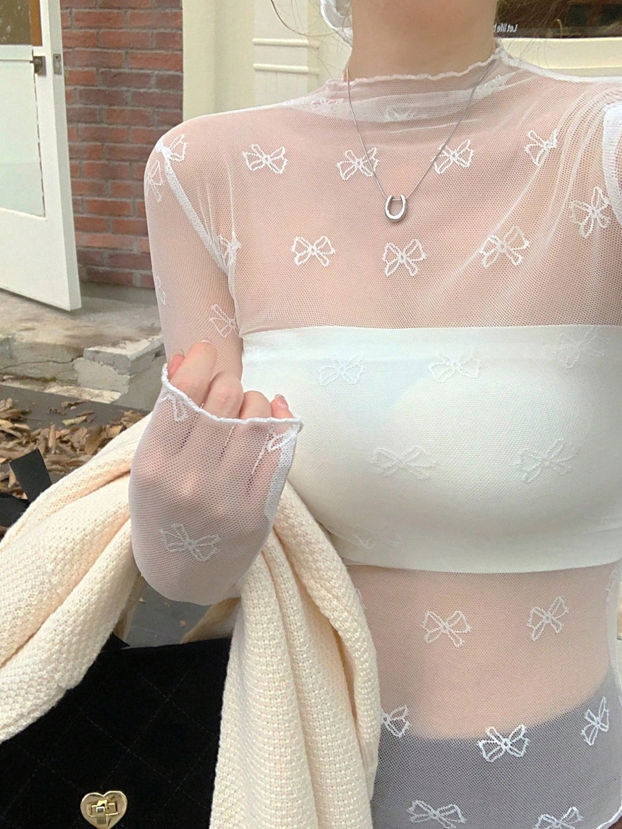 Sheer white mesh shirt with all-over bow print and lettuce trim cuffs.