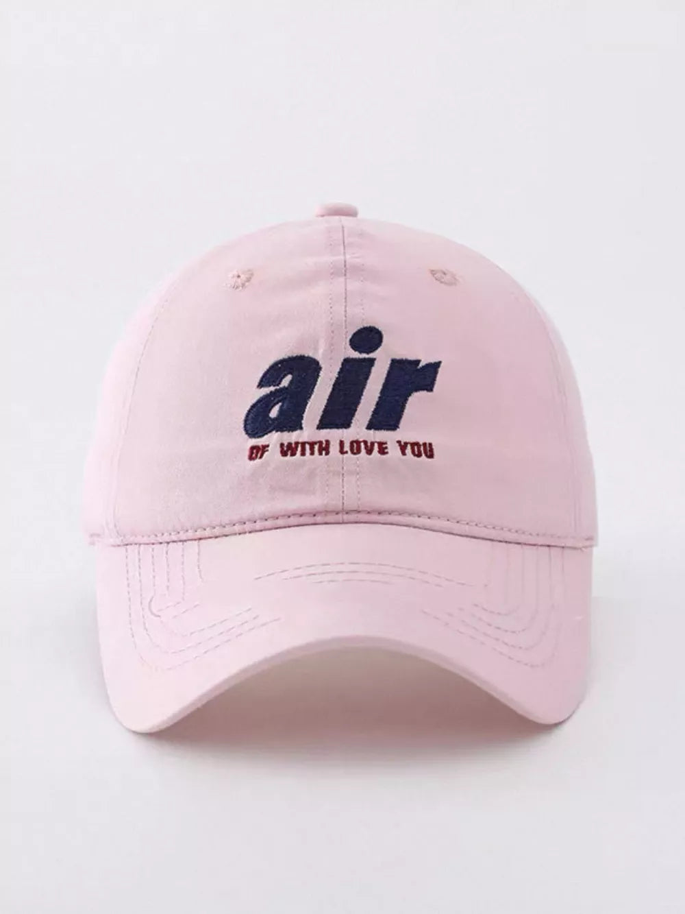 Light pink baseball cap with embroidered "air" text and smaller text below.