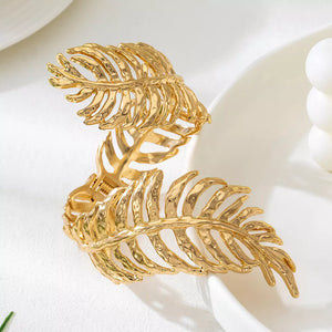 Gold bracelet featuring leaf design and floral