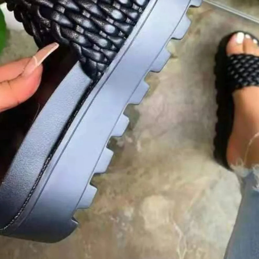 Black woven platform slide sandals with thick lug sole.