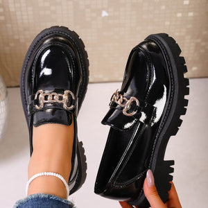 Gloss black patent chunky lug sole loafers with gold chain detail.