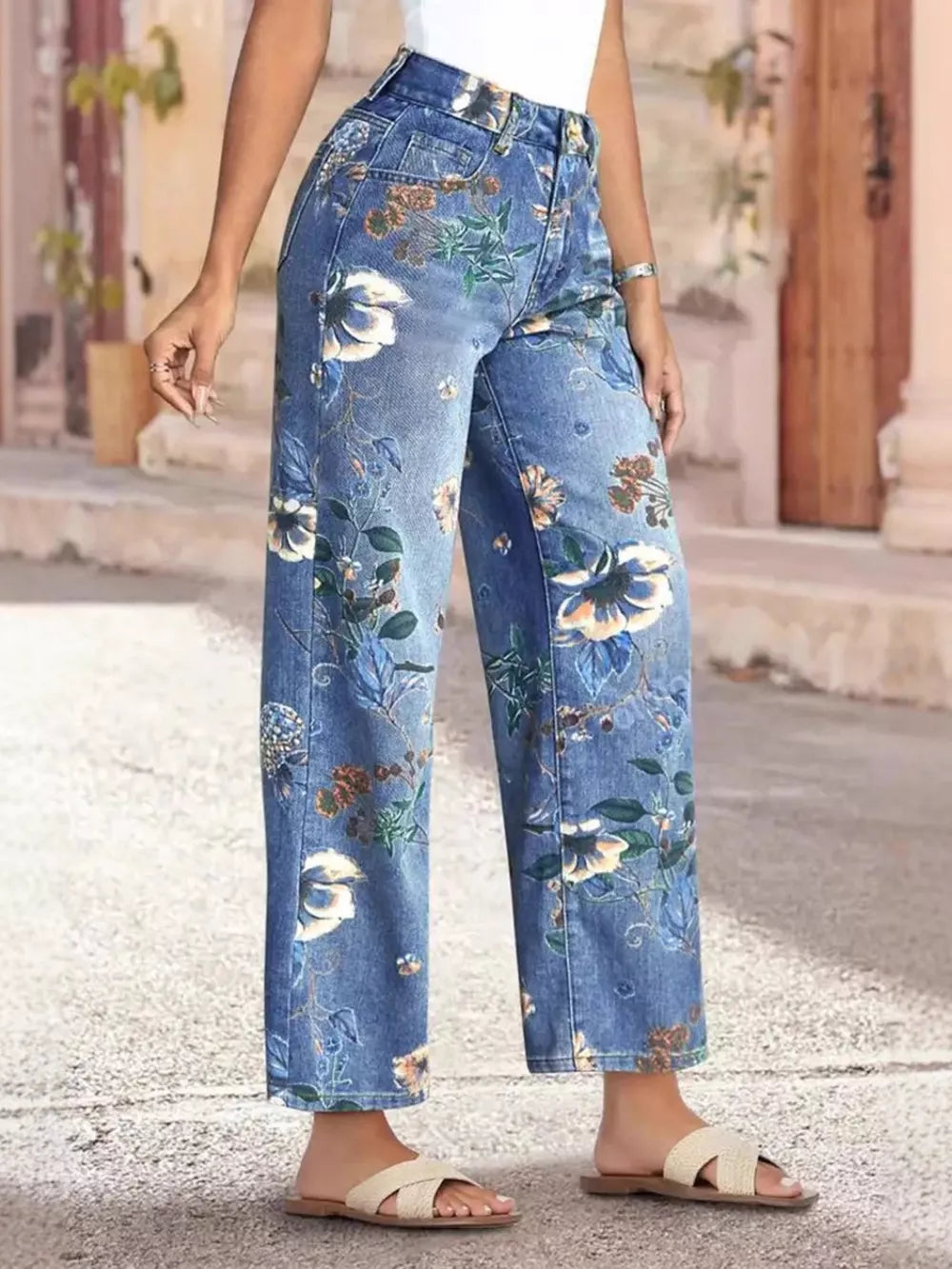 Light blue denim wide-leg jeans with a floral print and embellished details.