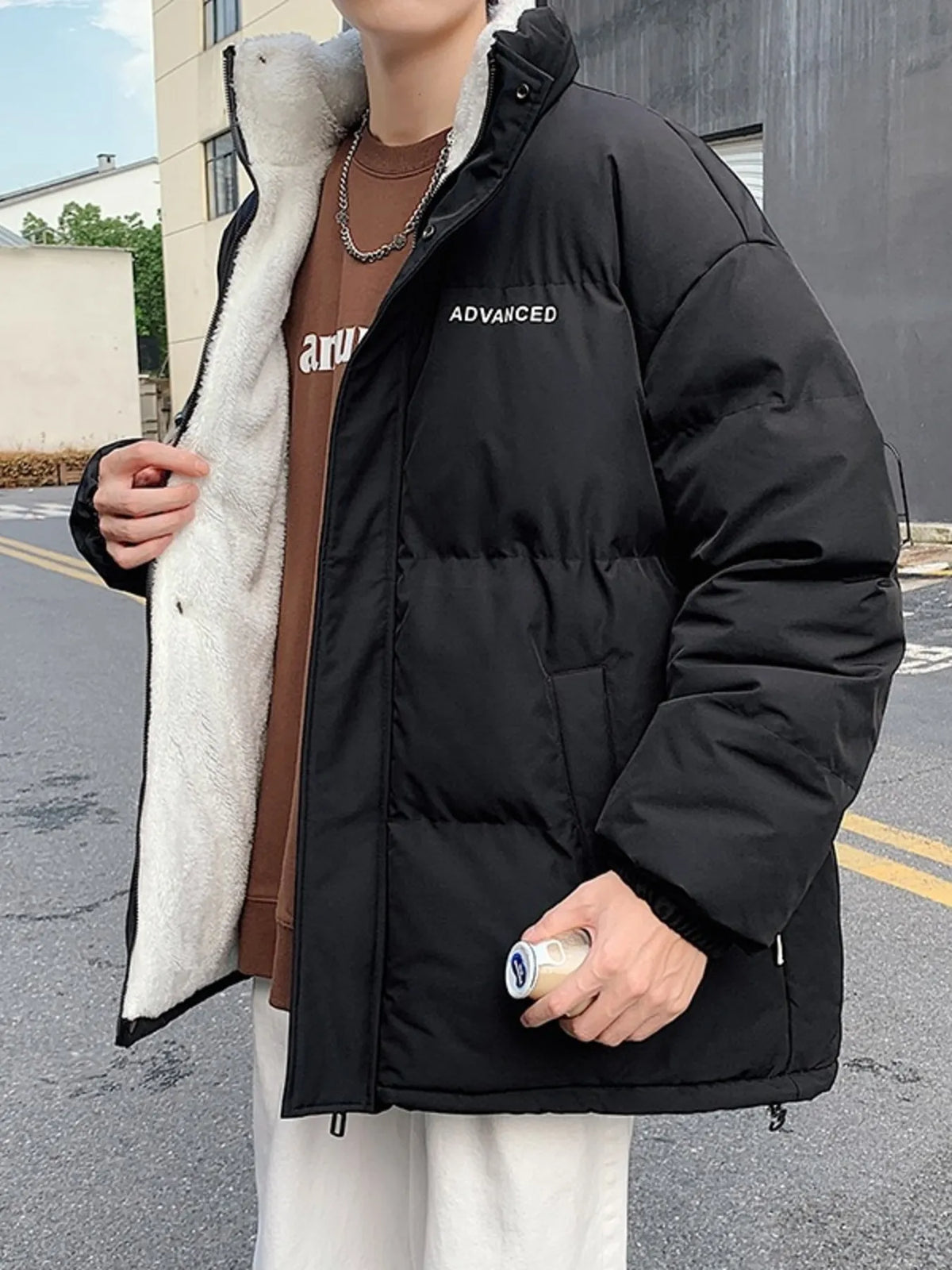 Black oversized quilted puffer jacket with sherpa lining and embroidered detail.