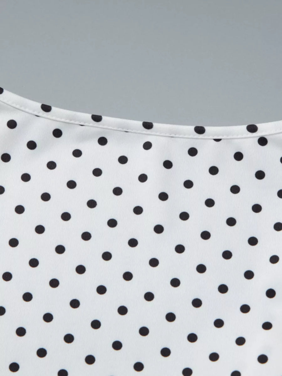 White t-shirt with black polka dots and a ruched detail at the neckline.