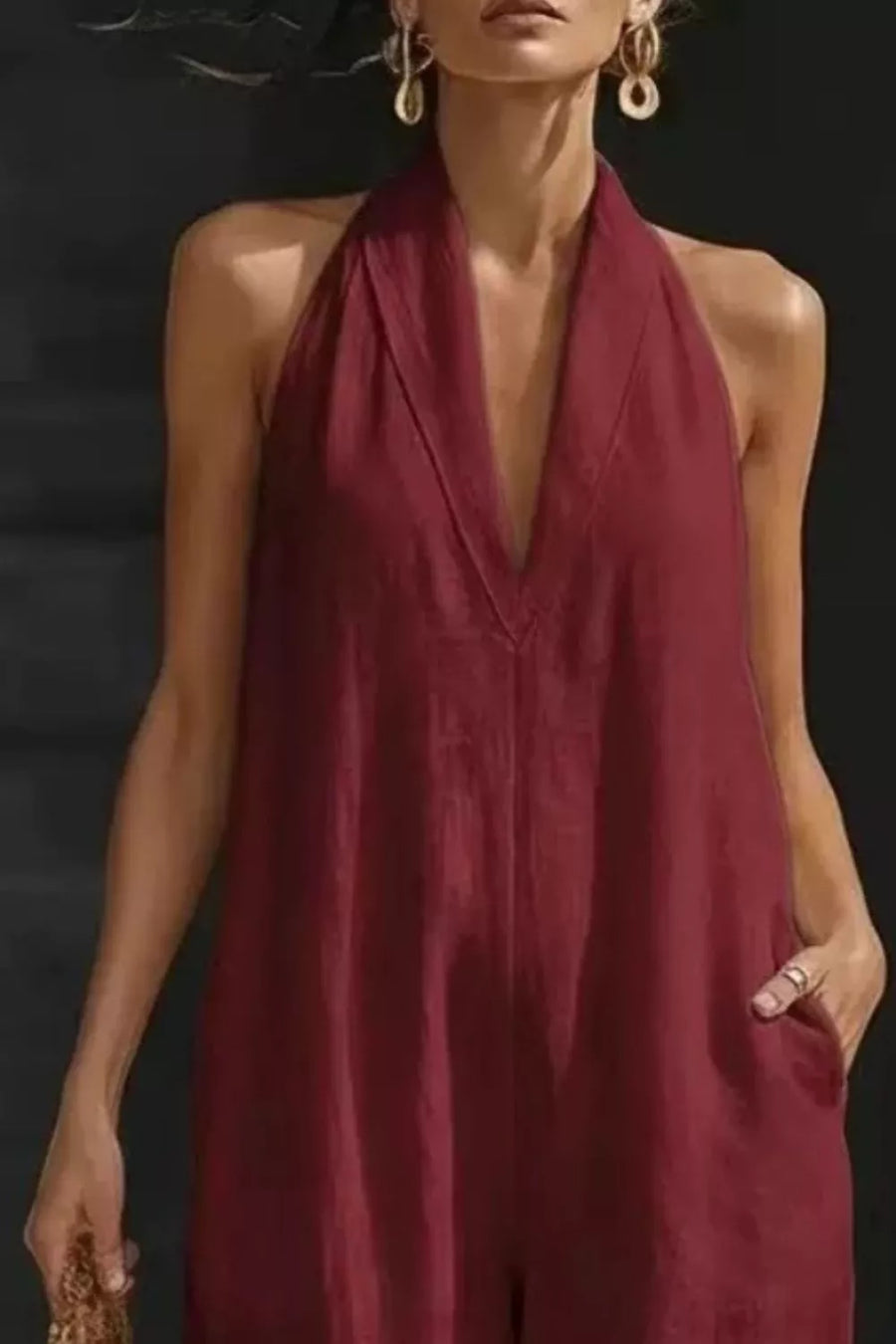 Burgundy halter-neck maternity jumpsuit with pockets, deep V-neck, sleeveless, relaxed fit.