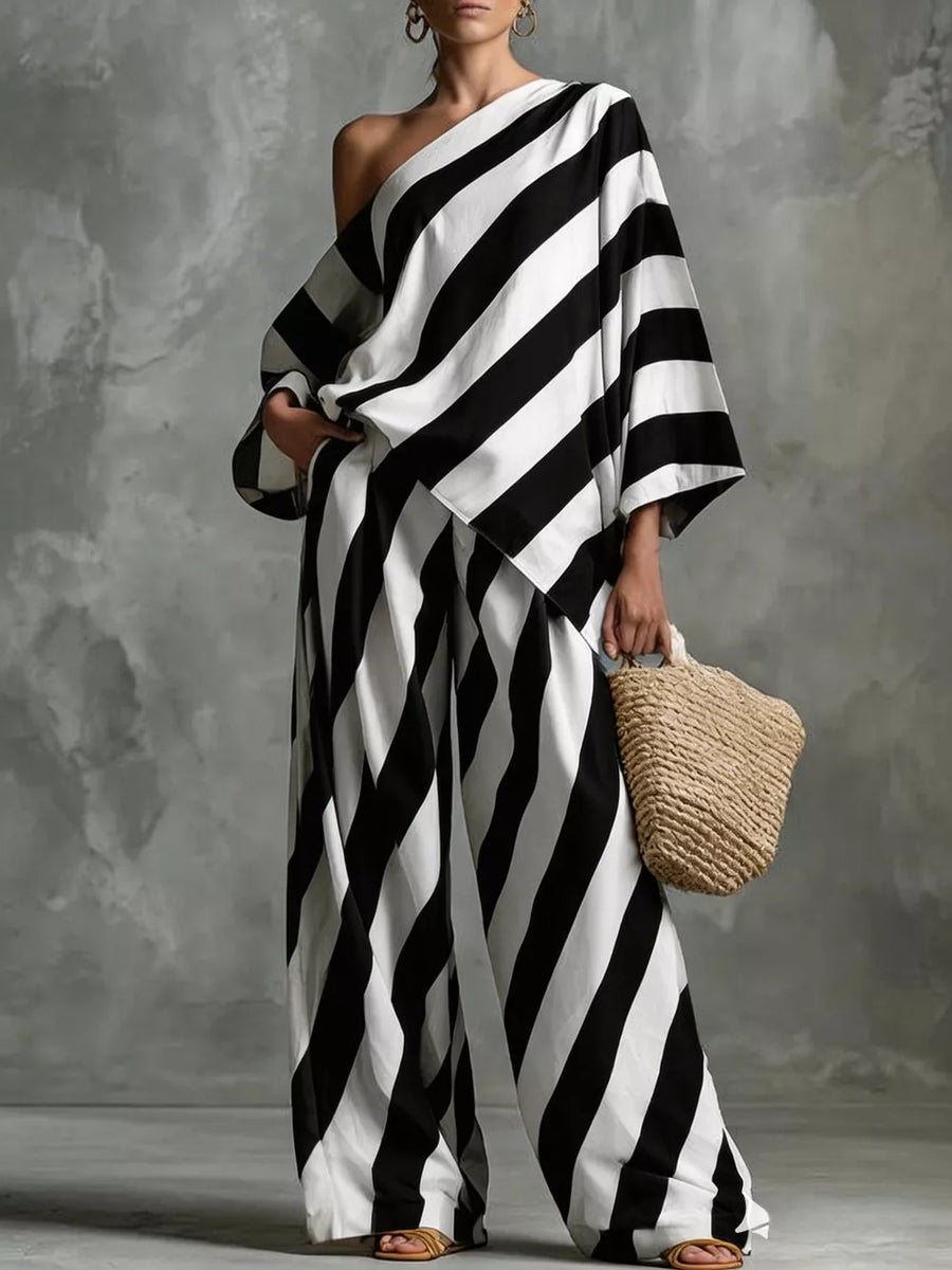 Black and white striped one-shoulder top and wide-leg pants set with a straw bag.