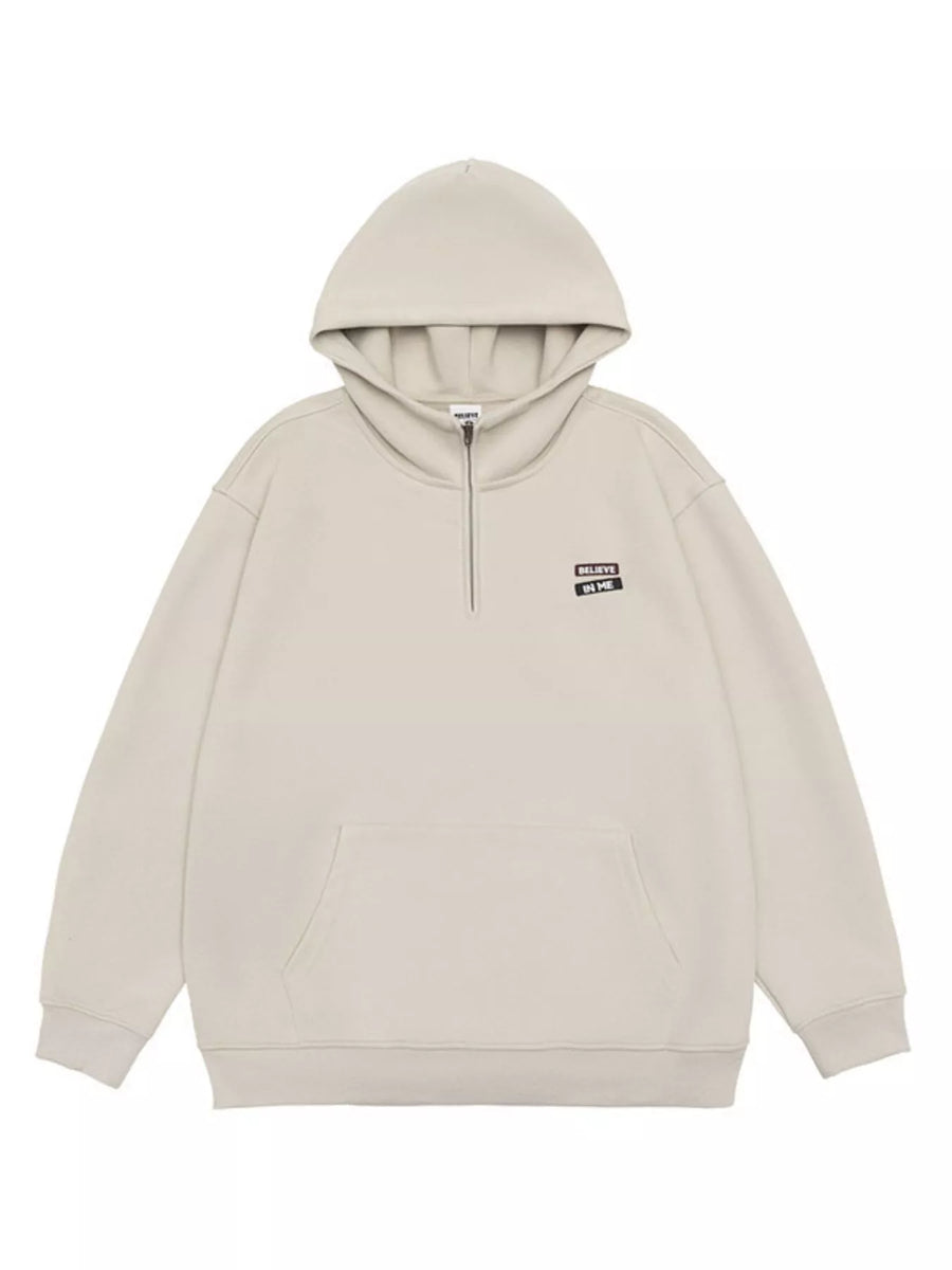 Plus-size beige quarter-zip hoodie with a front pocket and "Believe In Me" graphic.