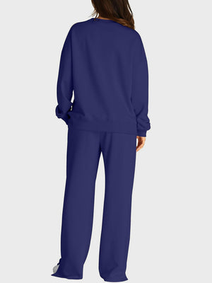 Dark blue loungewear set with crewneck sweatshirt and wide-leg trousers with slit front detail.