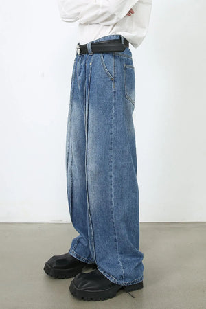 Medium wash denim trousers with prominent vertical seams and a wide leg