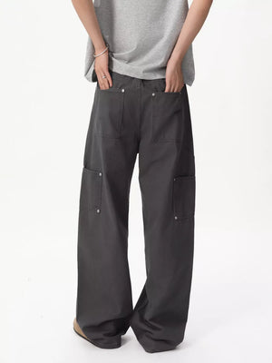 Relaxed wide-leg cargo pants in gray cotton with multiple buttoned pockets.