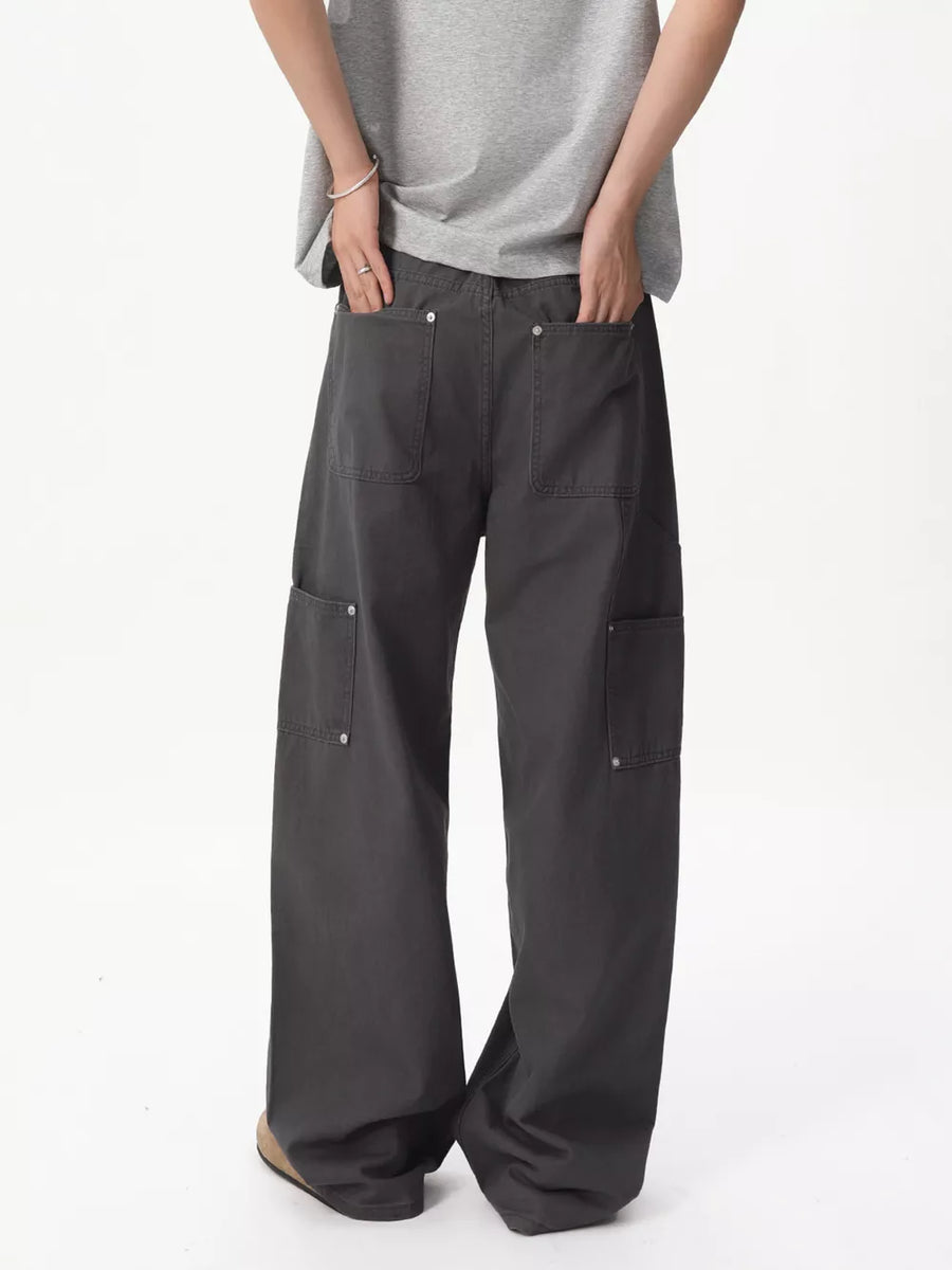 Relaxed wide-leg cargo pants in gray cotton with multiple buttoned pockets.