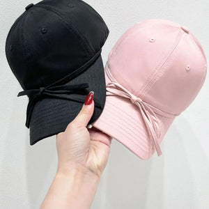 Baseball cap in blush pink and black with velvet bow detail